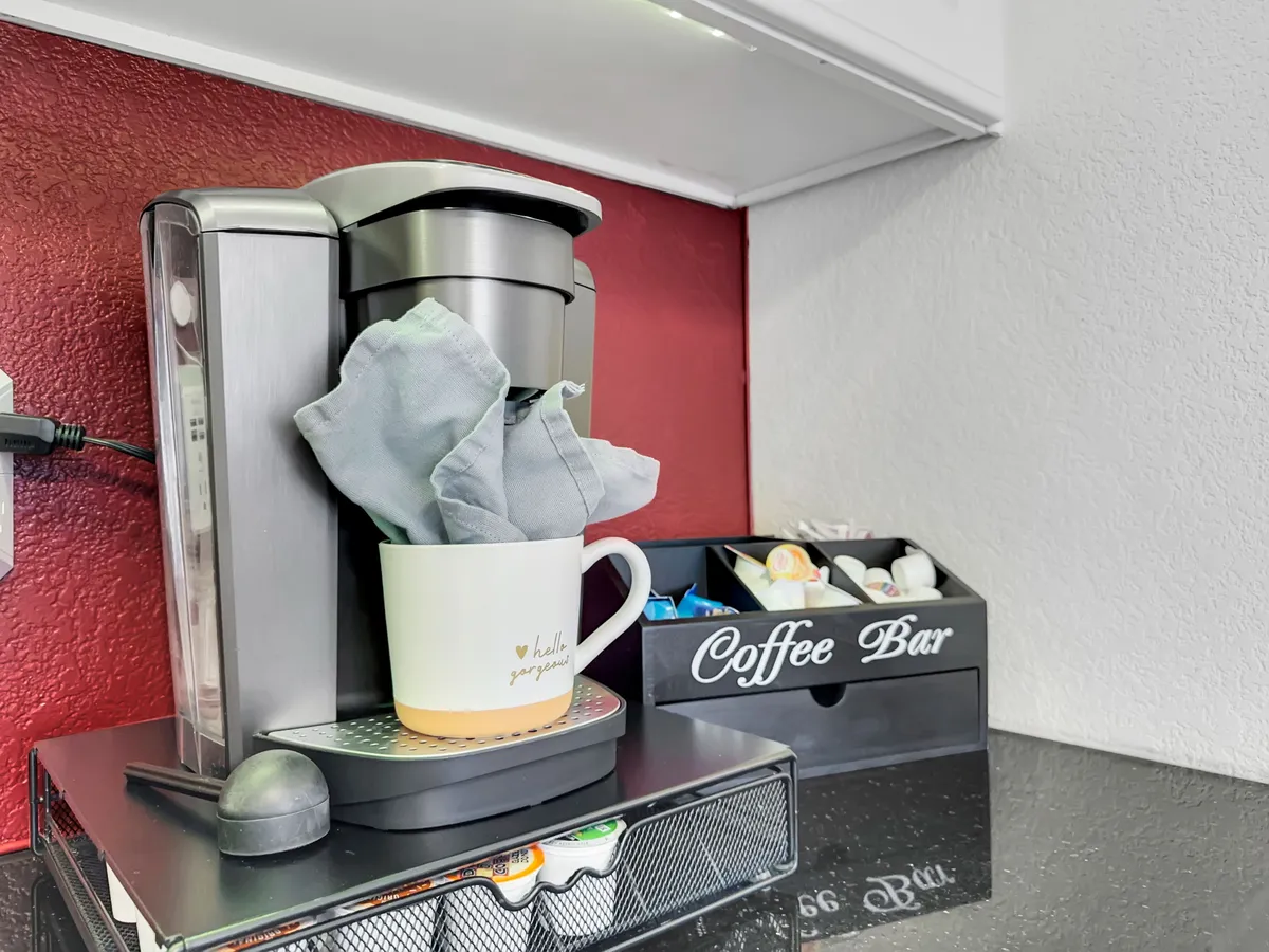 A dedicated coffee bar equipped with a modern coffee machine, mugs, and organized storage, suggesting a thoughtful setup for morning routines or breaks. The scene is cozy and well-organized, ideal for fueling productive work sessions.